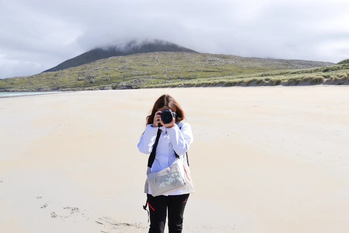 Photographe prend un cliché sur une plage.