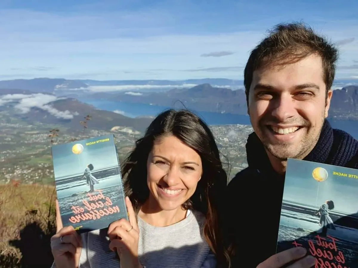 Les enfants de l'auteure Brigitte Hache présentent le roman de leur maman “Tout le ciel est nécessaire”, publié chez Eyrolles, ils sont au sommet d'une montagne, en arrière plan le lac du Bourget
