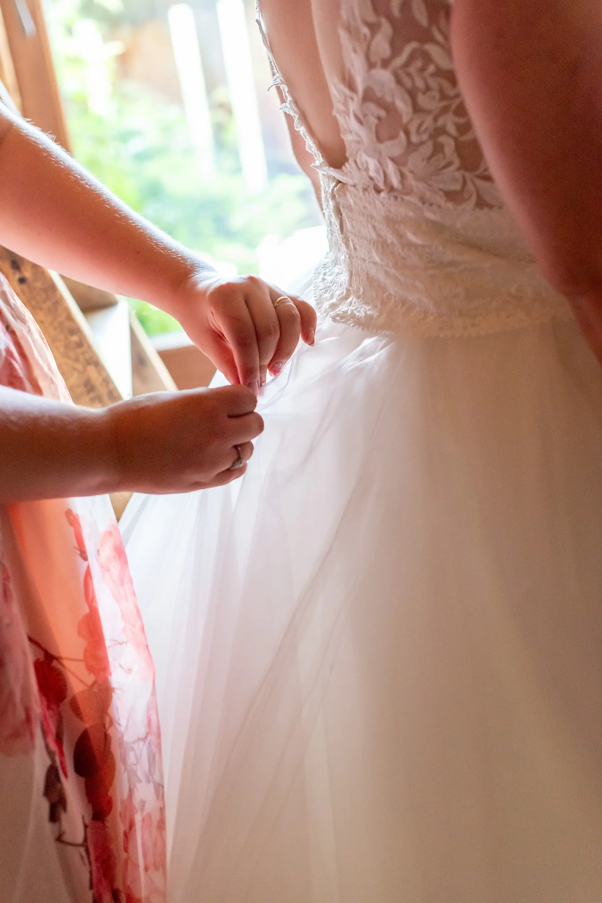 Détail de la main d'une femme qui ajuste une robe de mariée