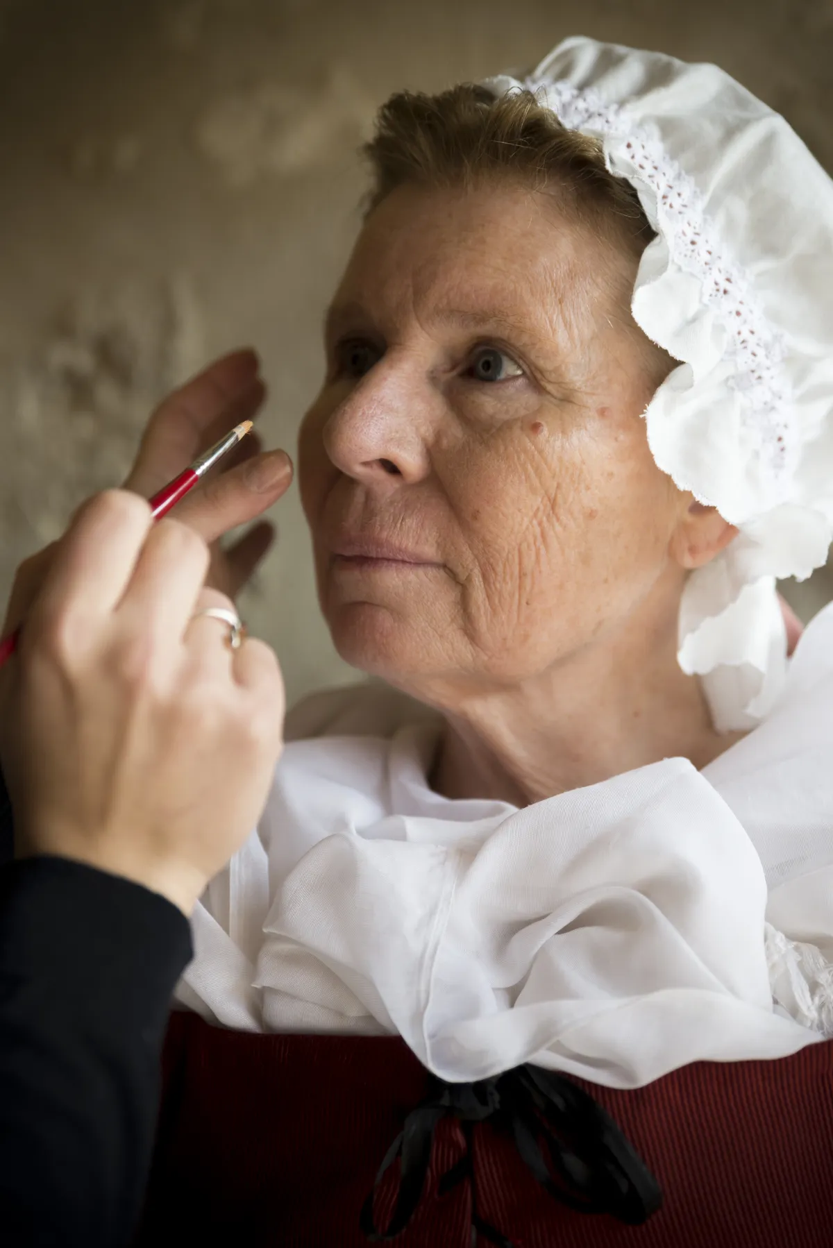 Photographe plateau cinéma Haute-Savoie - une actrice en costume d'époque se fait maquiller
