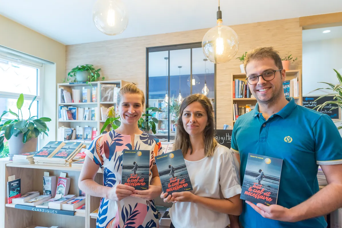 Une libraire et les deux enfants de l'auteure Brigitte Hache présentent son dernier roman Tout le ciel est nécessaire publié chez Eyrolles, dans une jolie librairie