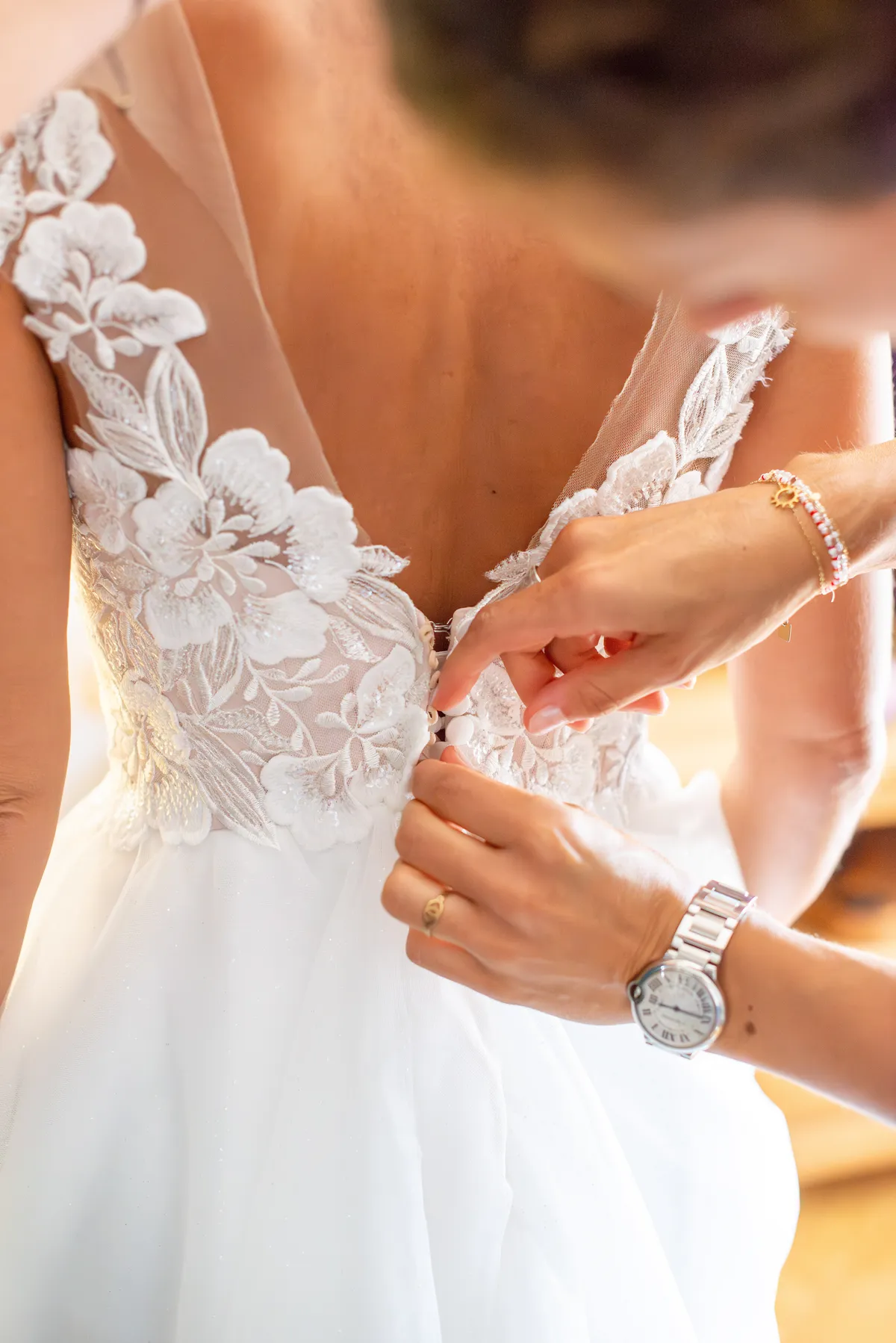 Préparatifs de la mariée avec l'enfilage de la robe 