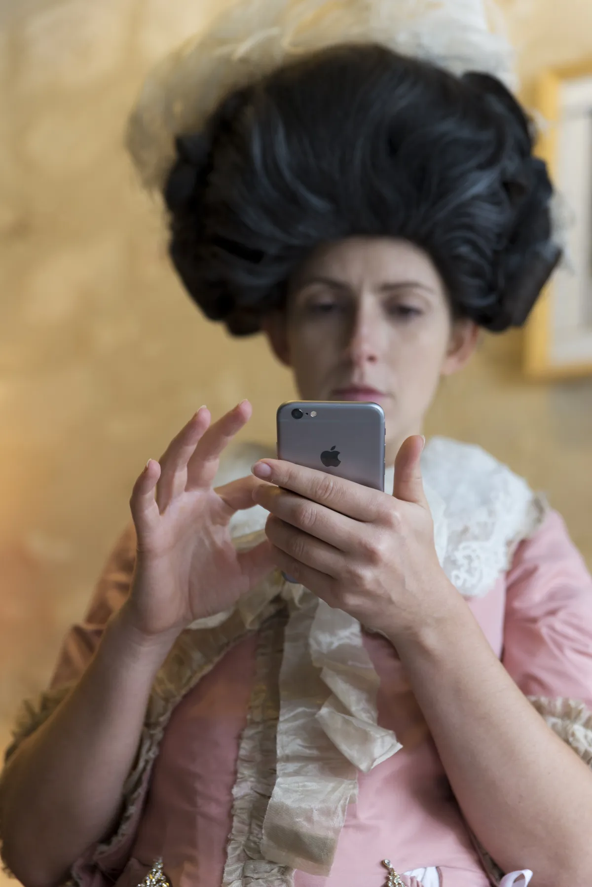 Photographe tournage cinéma Lyon - une comédienne en costume d'époque regarde son téléphone portable  