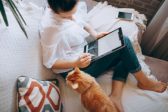 Woman working on tablet next to cat