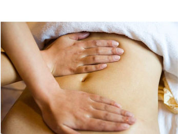 Therapist with hands on client's abdomen