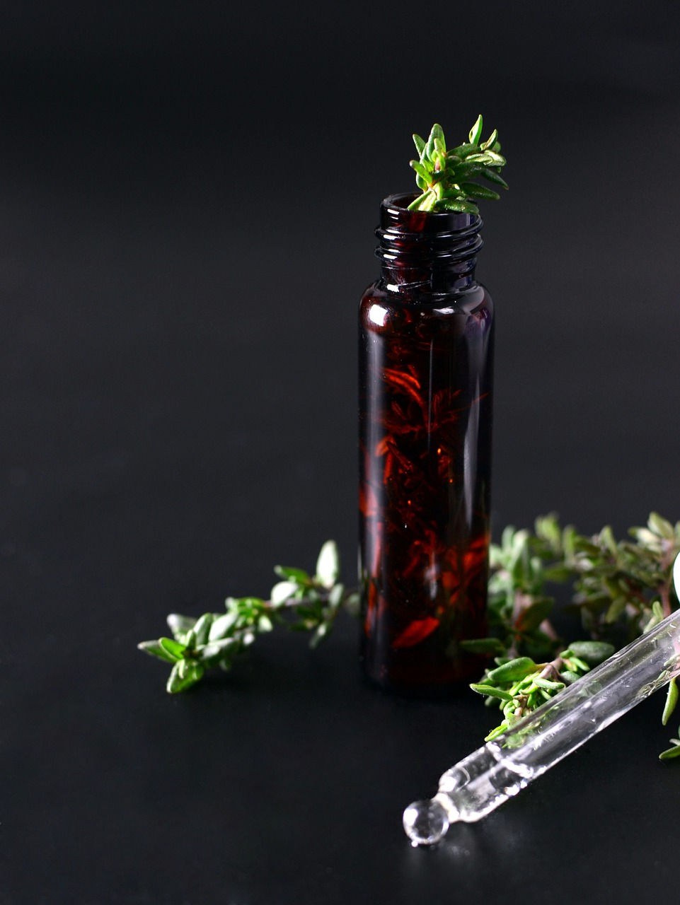 Vidro roll-on, com galhos de tomilho. Uso em aromaterapia.