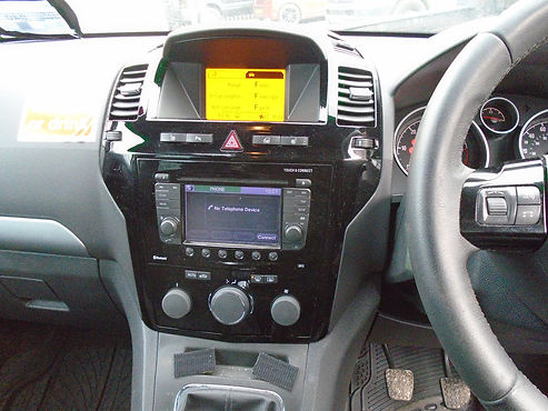 Car dashboard displaying central touchscreen display heating unit controls and steering wheel layout