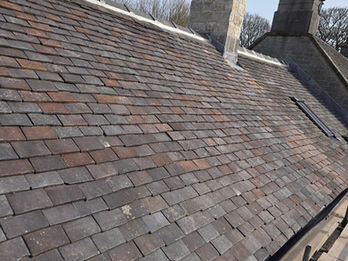 Tiled roof section undergoing maintenance and ridge tile checks