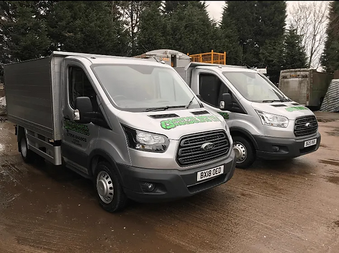 Two silver scrap metal collection vans parked outdoors on a paved area