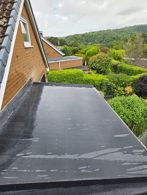 Smooth, newly installed black felt flat roof over a garage