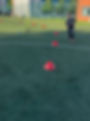 Young footballer standing on artificial turf pitch during training drill set with red cones