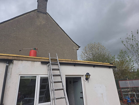 Ladder resting against the roof edge of a residential building during roof work