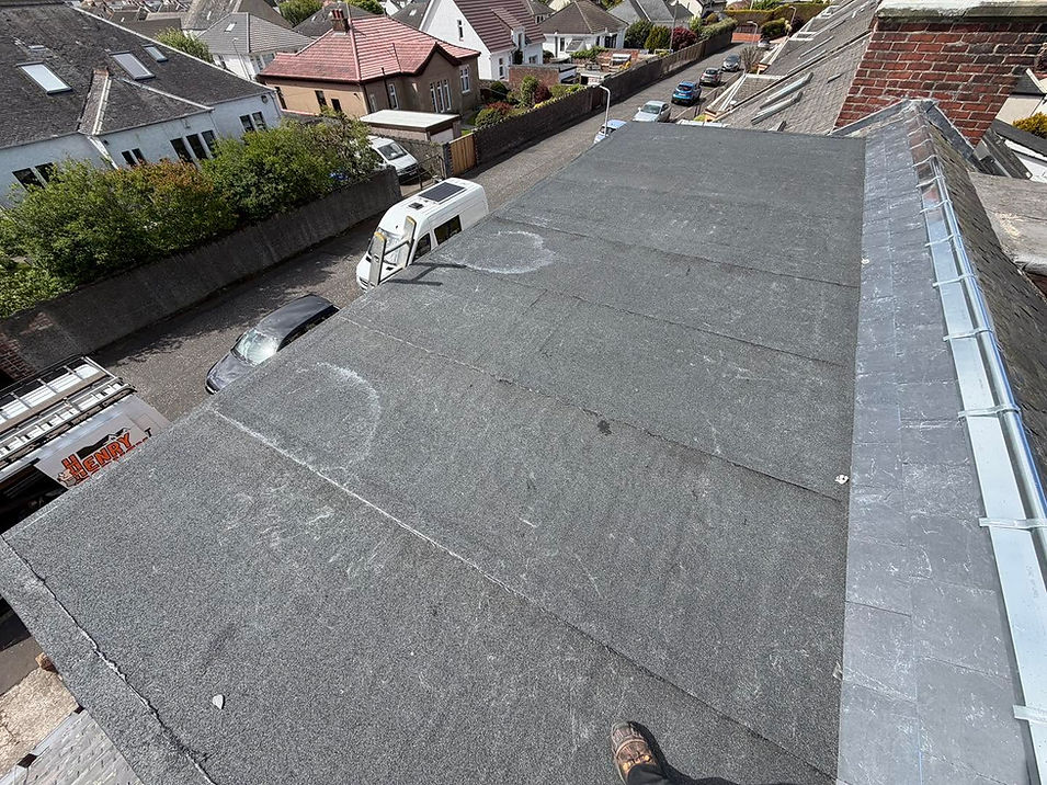 High-angle view of a flat felt roof installation on a residential building