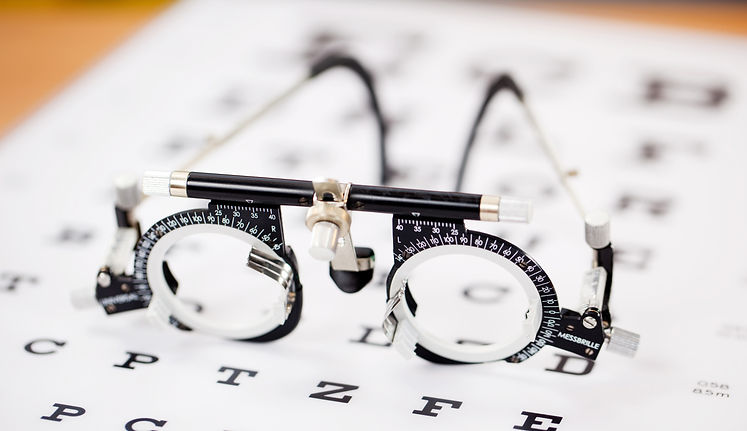 Close-up of an optometry trial frame resting on an eye chart
