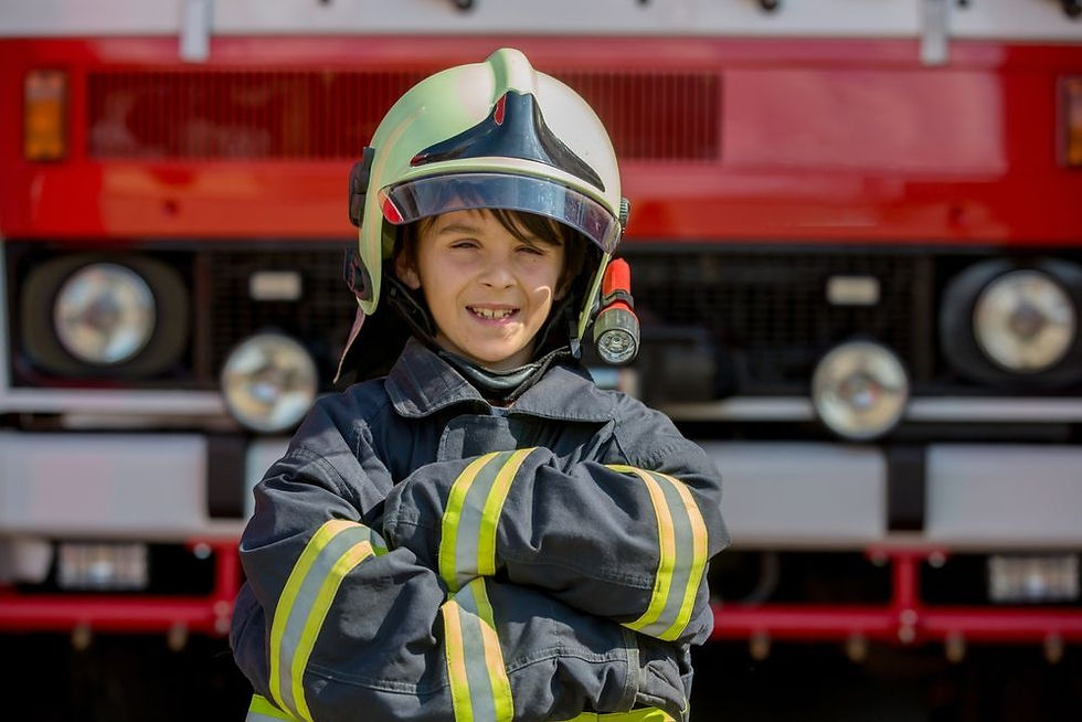 Child wearing firefighter protective gear and helmet