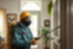 Pest control worker in a green uniform standing inside a clean home