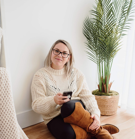 Aimee Owner of Aimee Rae Photography sitting on the floor