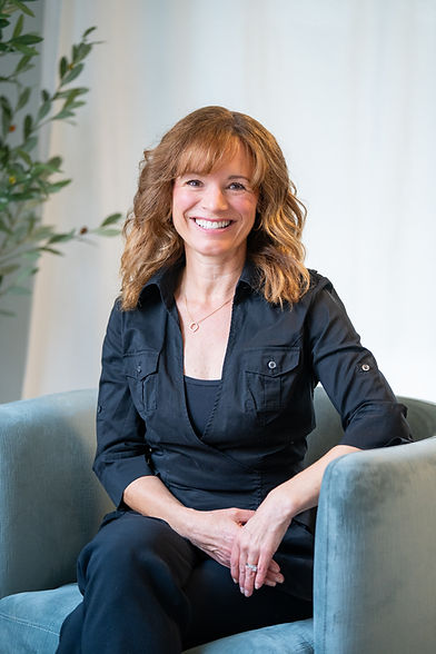 Portrait of Stacie, owner and esthetician at The Skin Sanctuary, smiling in her professional spa setting.