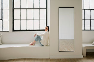 Brittany smiling in a bright relaxed wellness setting