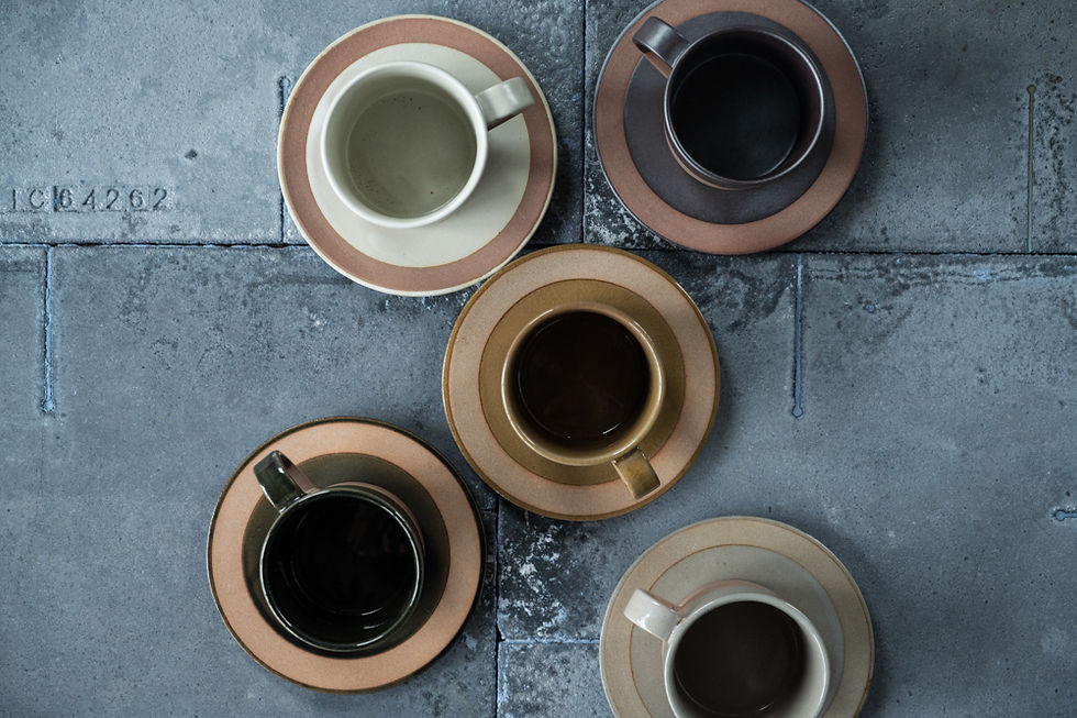 Thumbnail: Four coffee cups and saucers on a stone surface