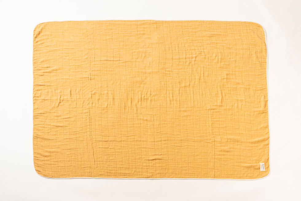 Thumbnail: A large, pale orange, cotton gauze blanket — made in Japan by Blanked — laid out flat to show its subtle pattern of straight stitched lines.