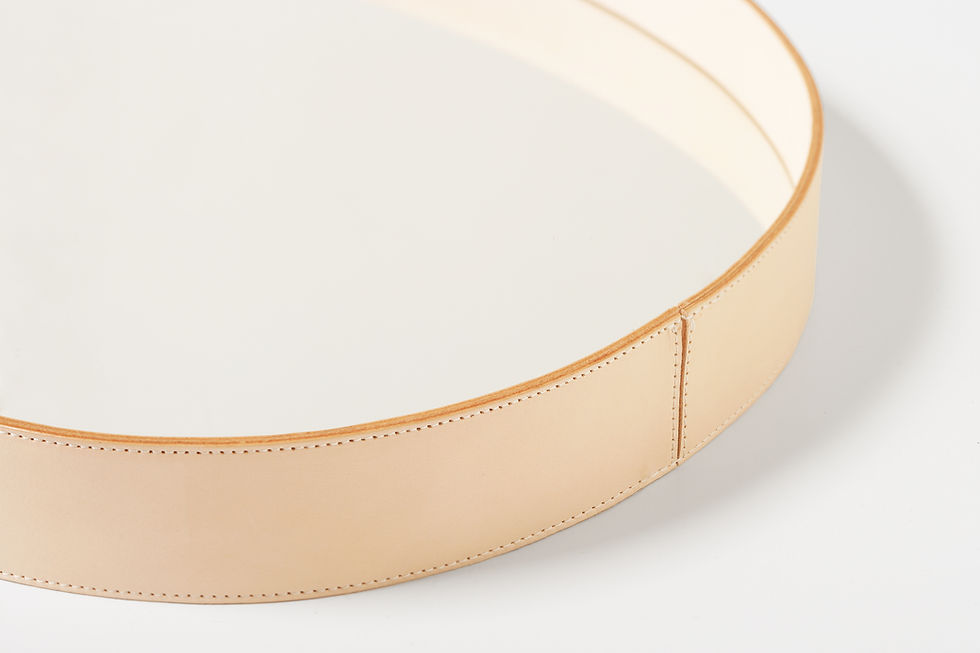 Thumbnail: Detail of the natural tan leather frame of an oval wall mirror, showcasing its stitching