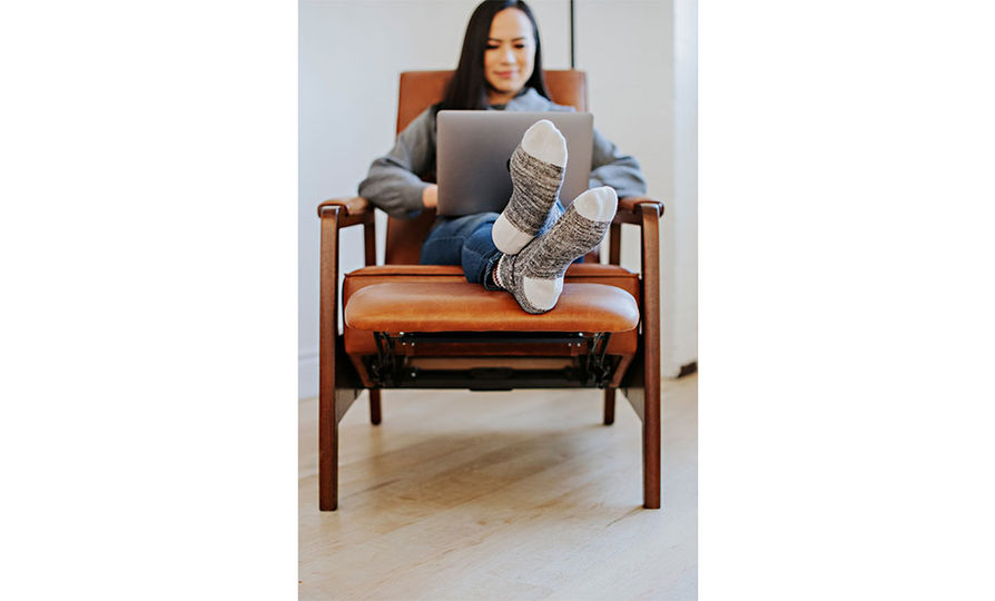 Woman working on laptop with feet kicked back in the Oxford Recliner from Vogel