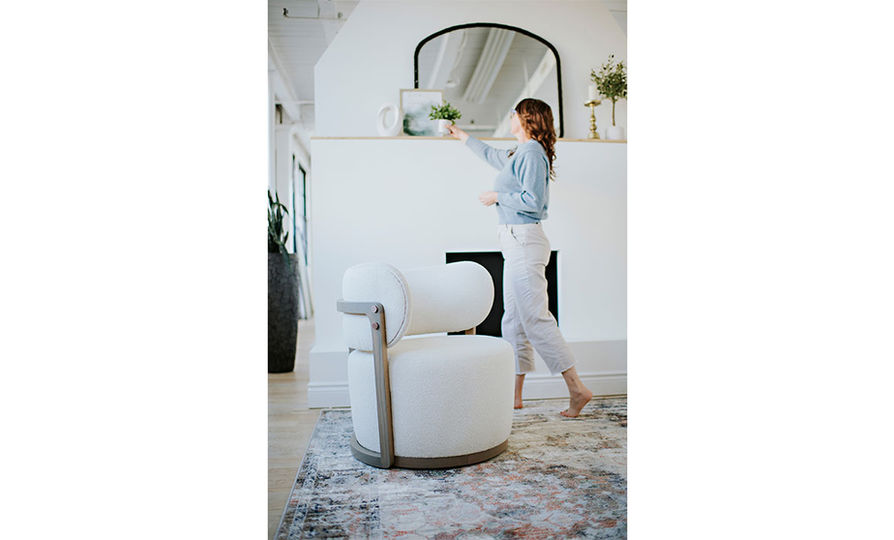 a contemporary white accent chair in a white living room