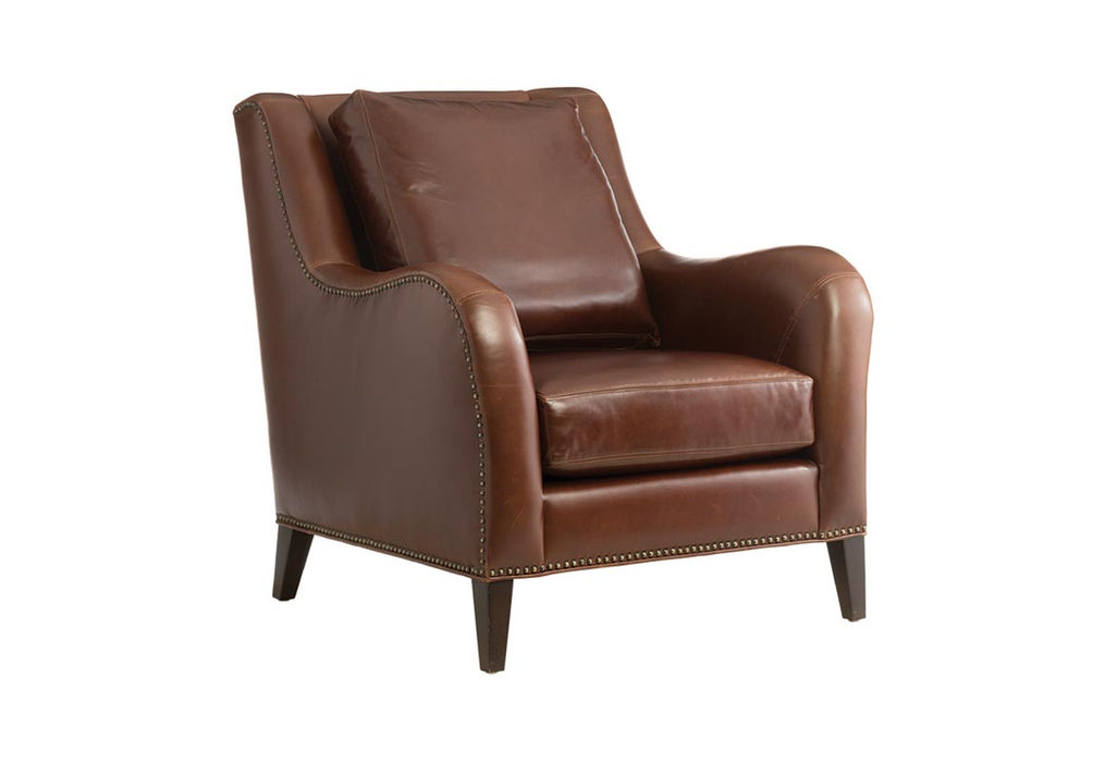 Traditional club chair with curved arms and nail head trim in a traditional brown leather