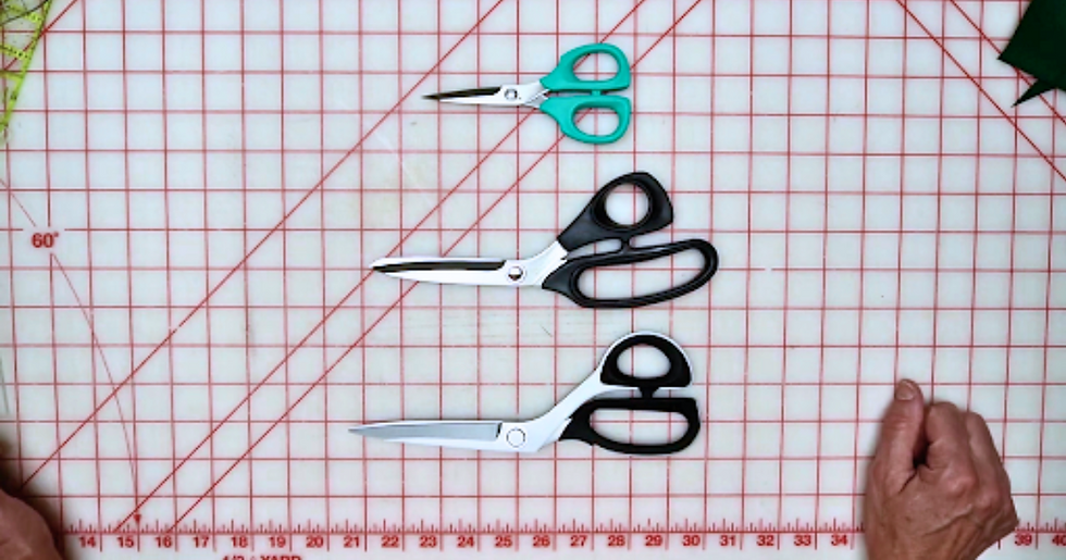 Three pairs of scissors on a cutting mat