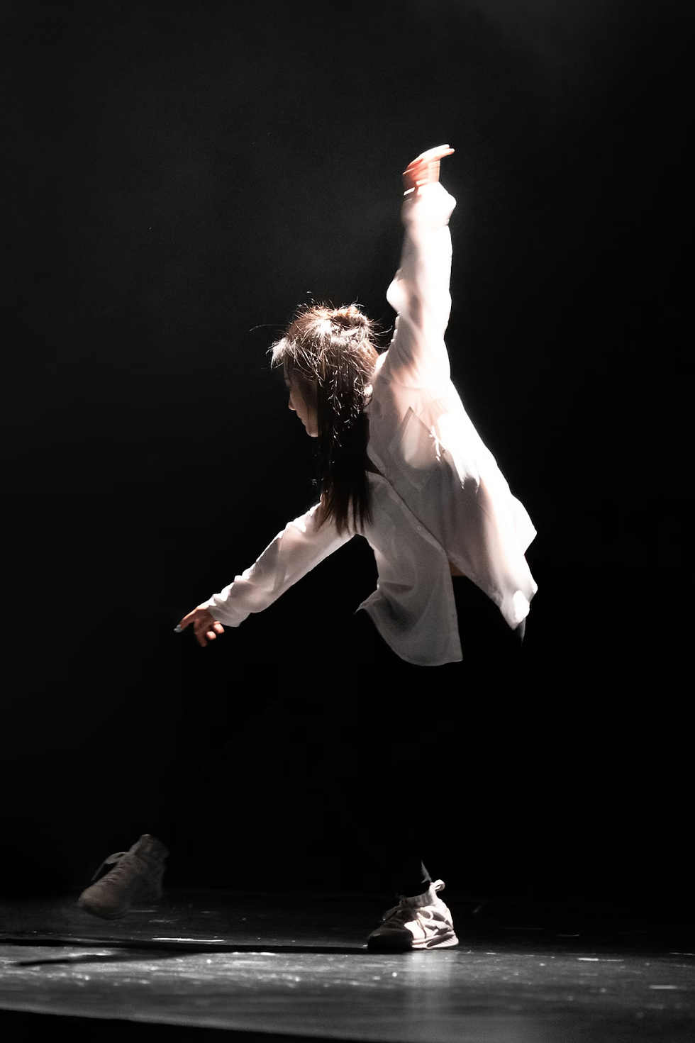 a woman dancing in a black room