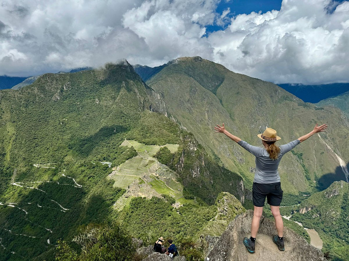 Hiker enjoying the panoramic view of Machu Picchu from the summit of Huayna Picchu in Peru