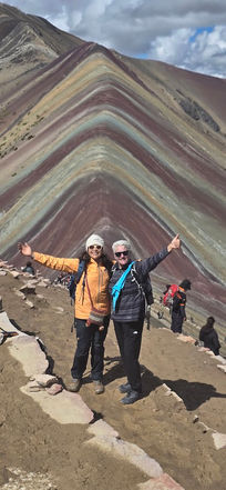 Travelers posing at the colorful slopes of Rainbow Mountain Vinicunca during a trekking adventure in Cusco Peru