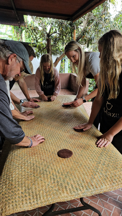Group of participants making artisanal chocolate in a traditional way during the workshop.