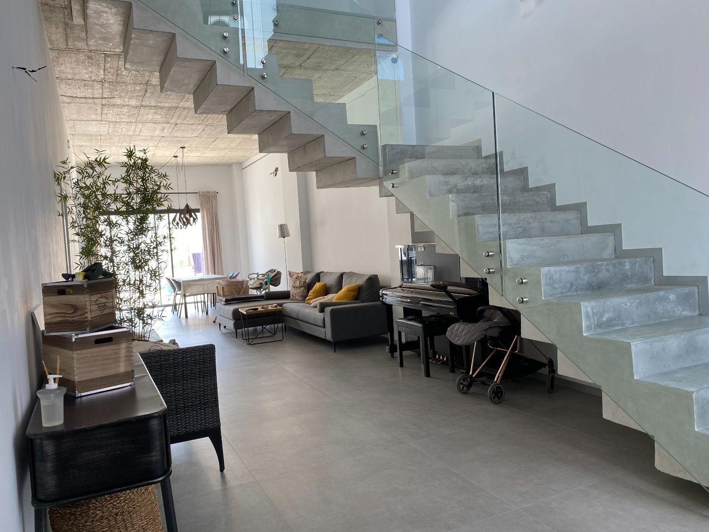 Escalera moderna con peldaños macizos y barandilla de vidrio en vivienda unifamiliar Casa Chiva diseñada por Genovés Calleja Arquitectos, con espacio abierto y acabados contemporáneos.