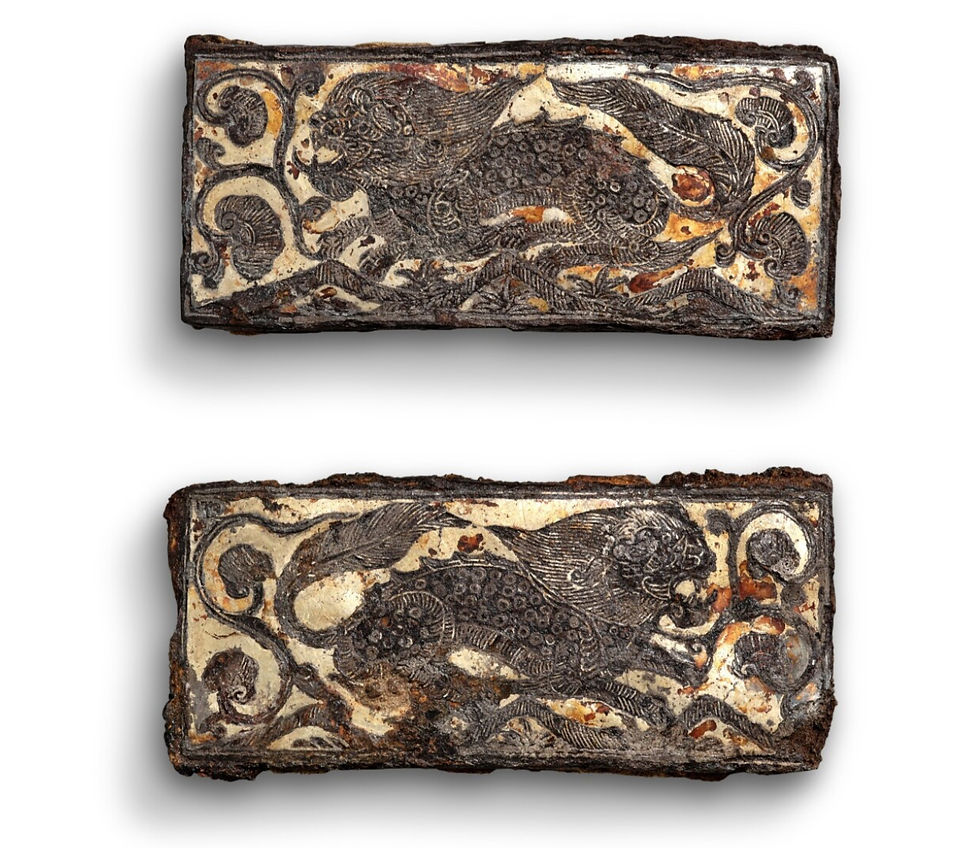 Two rectangular metal plates with intricate engravings of lions and swirling patterns, featuring a weathered black and brown finish.