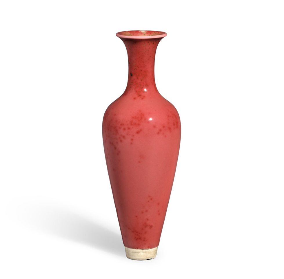 拍賣筆記 vol.287 蘇富比香港:622.3萬港元成交,清康熙豇豆紅釉柳葉瓶,岡田美術館 - An Okada Museum Peachbloom-Glazed Willow-Leaf Vase, Mark And Period Of Kangxi Sold for 6.223m HKD / Tall red ceramic vase with a speckled pattern on a white background. The glossy finish reflects light, creating a simple yet elegant mood.