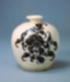 東京富士美術館:白地鉄絵牡丹文瓶 White vase with bold black floral design, set against a plain blue background. The vase is rounded with a narrow top, creating a classic look.