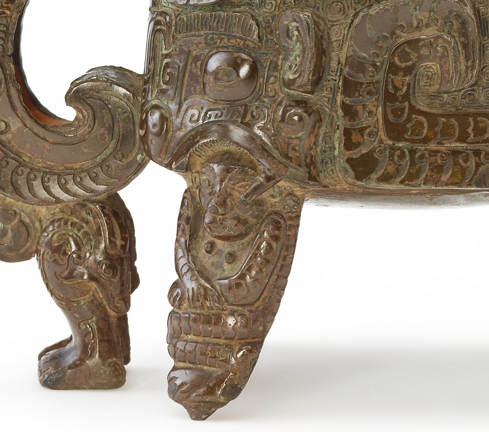 弗利爾美術館:商代青銅方觥 Ornate bronze sculpture with intricate carvings, featuring patterns and faces. The piece has an aged patina, adding an ancient, mystical feel.