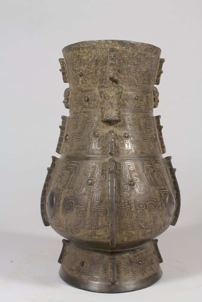 波特蘭博物館：商代安陽青銅饕餮紋壺 Ancient bronze vessel with intricate patterns, featuring swirl designs, against a plain light background. No text is visible.