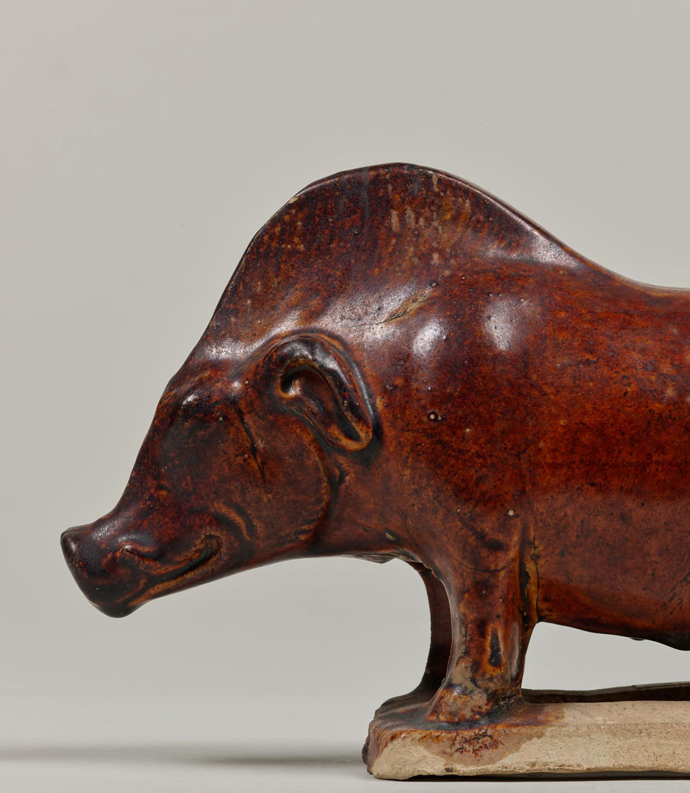 東京國立博物館:唐三彩褐釉豬 Brown ceramic boar sculpture with a smooth surface, set against a plain background. The piece has a serene, rustic appearance.