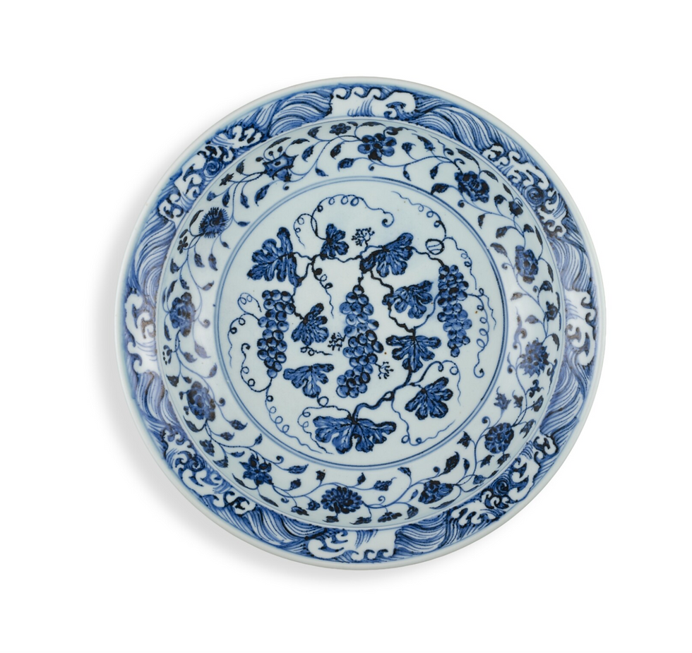 拍賣筆記 vol.286 蘇富比香港:1843.1萬港元售出,明永樂青花葡萄紋折沿菱口盤,岡田美術館 - An Exceptional And Rare Blue And White Barbed 'Grape' Charger, Ming Dynasty, Yongle Period, Sold for 18.431m HKD / Blue and white ceramic plate with intricate grapevine design. Floral and wave patterns adorn the edges, creating an elegant look.