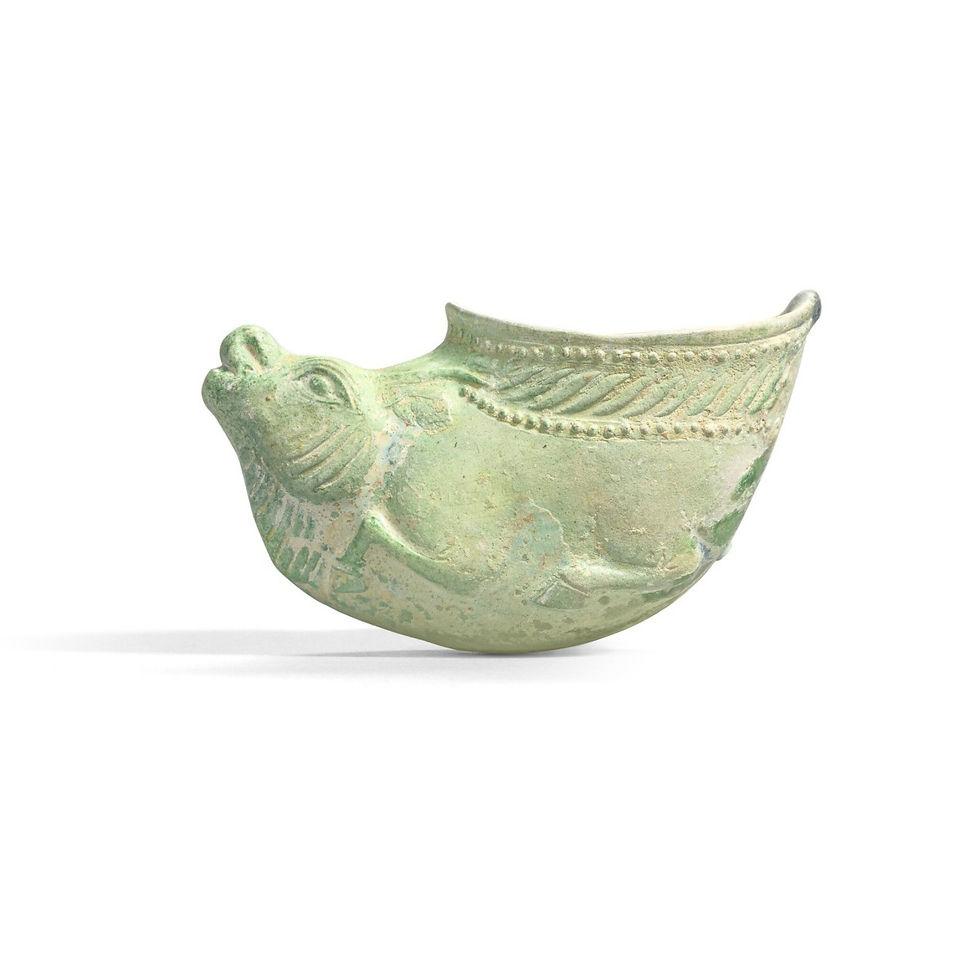 Green, fish-shaped ceramic vessel with embossed patterns and a spout. The background is plain, highlighting its antique texture and design.