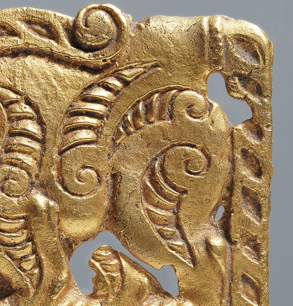 寧夏固原博物館:春秋戰國動物紋金飾牌 Ornate gold decorative panel with intricate swirling patterns and motifs, set against a plain gray background.