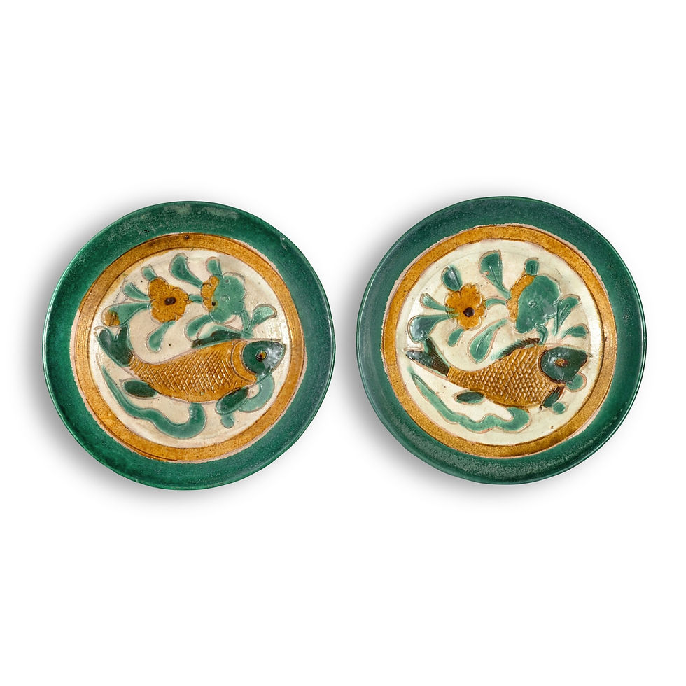 Two round ceramic plates with green rims show gold fish and teal flowers on cream backgrounds against a white backdrop.