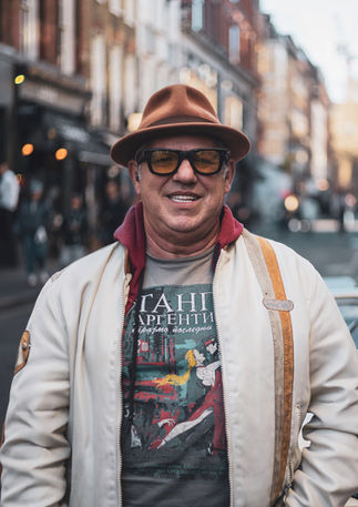 A middle aged man wearing a hat and sunglasses poses in front of his vintage car. Image (c) Lenny Di Lorenzo.