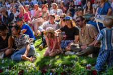 An audience watches outdoor live performances.
