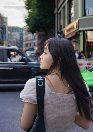 A young asian woman looks left before crossing the street in central London. Image (c) Lenny Di Lorenzo.