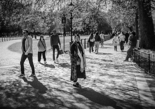 A Middle Eastern woman looks lost in a London park. Image (c) Lenny Di Lorenzo.