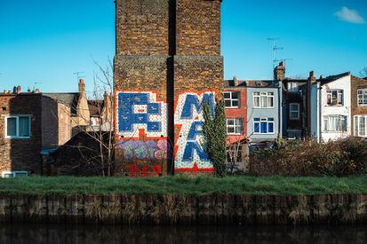 Graffiti on a brick wall near a canal. Image (c) Lenny Di Lorenzo.